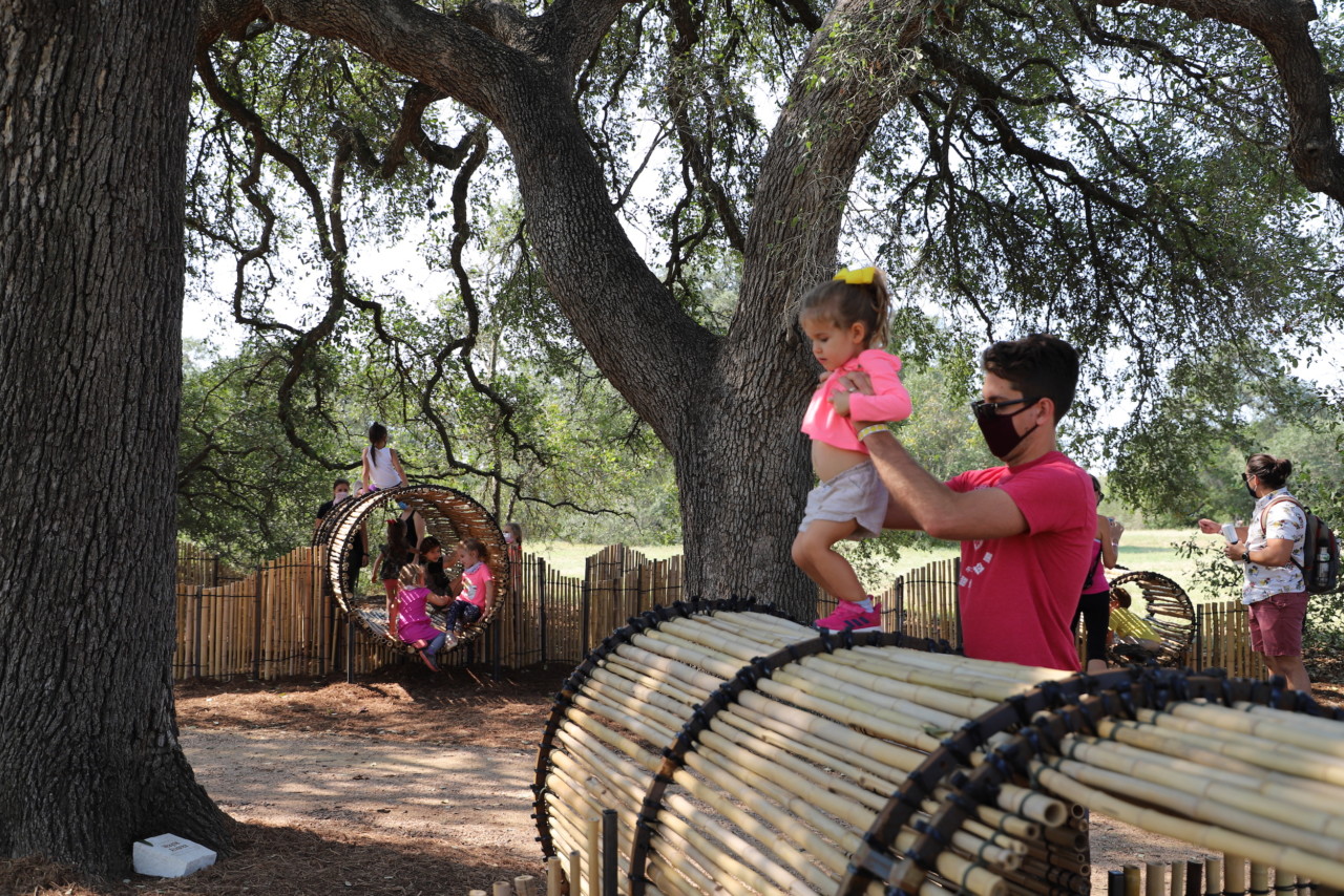 children and parents playing in a play structure