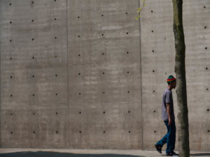 a man in front of a concrete wall designed by tadao ando