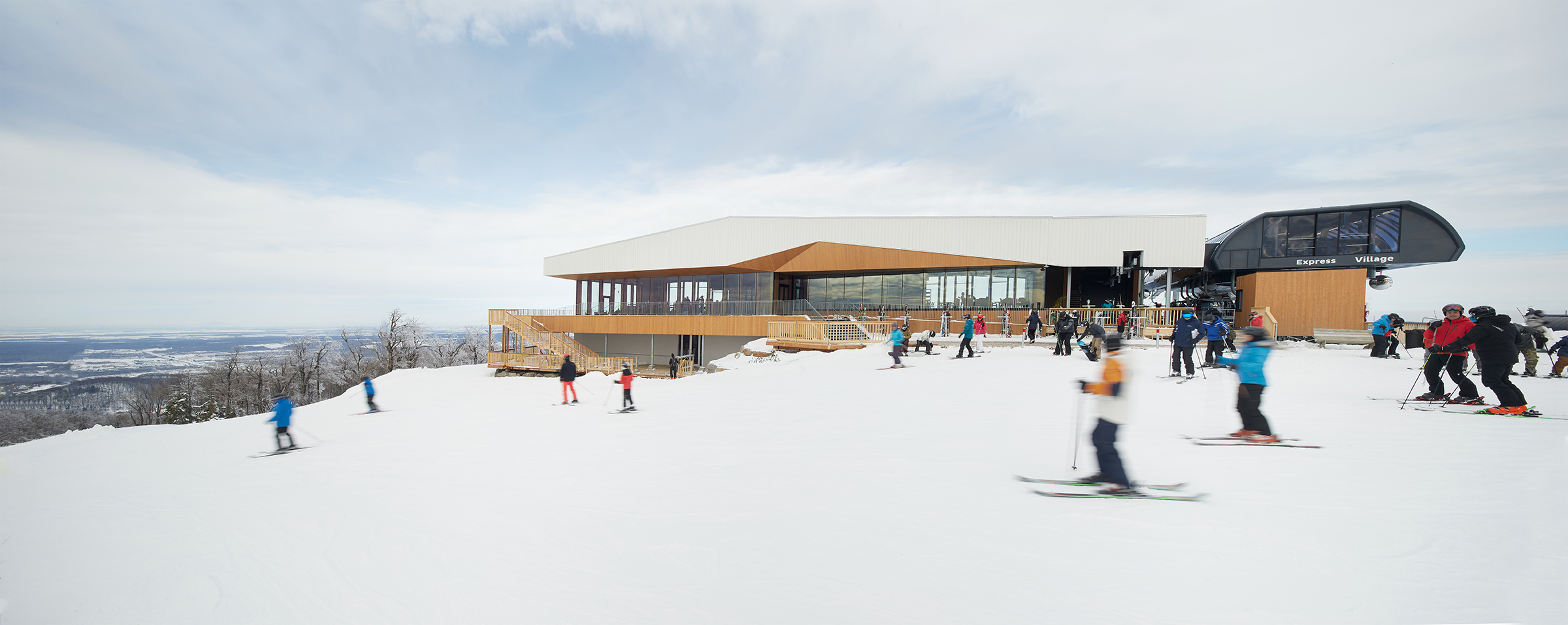 People on a ski slope with chalet behind