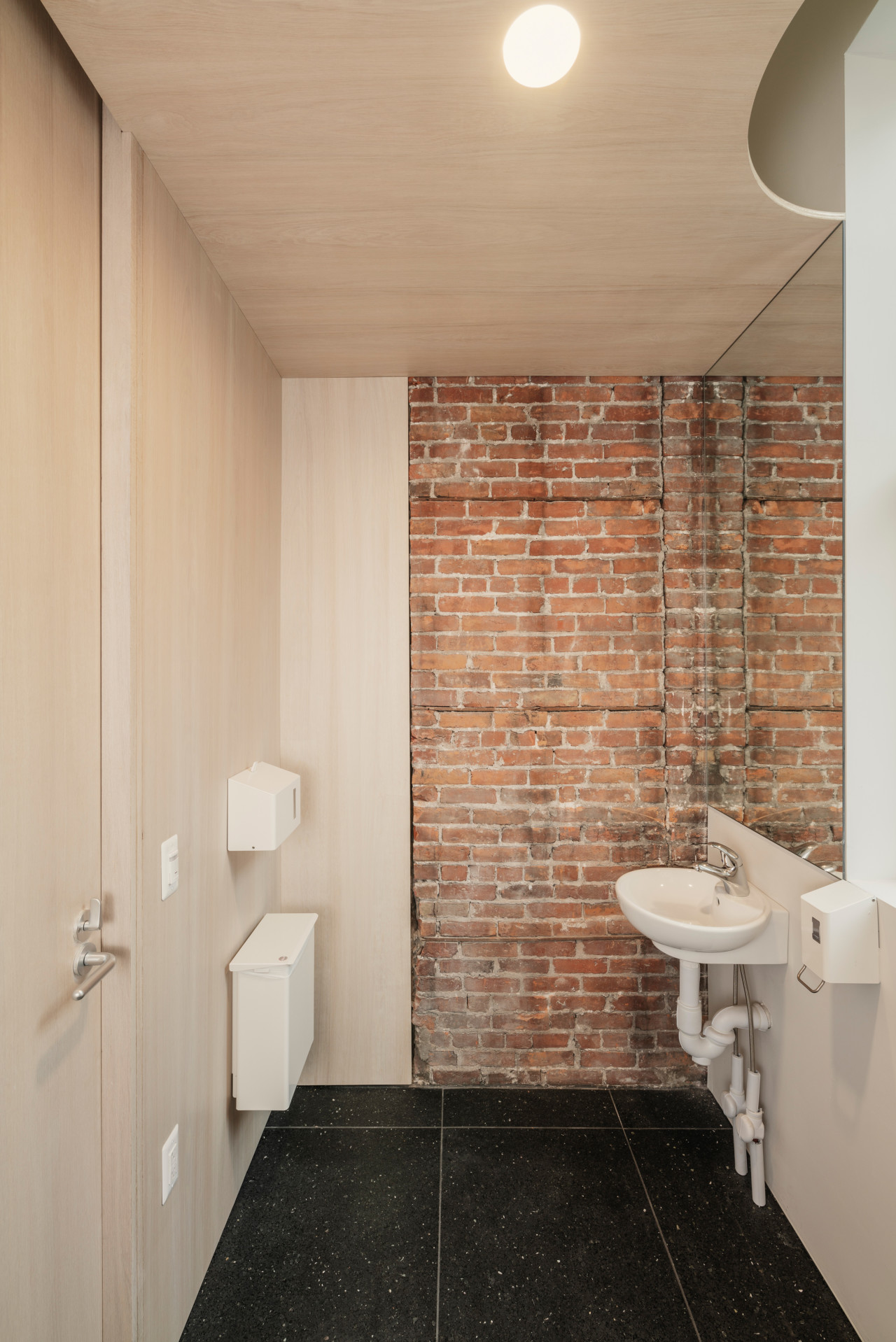 A bathroom with exposed brick