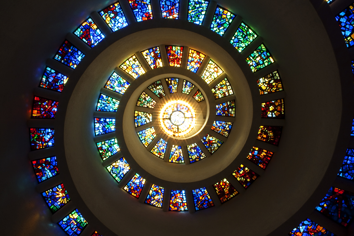 a spiraling chapel ceiling with stained glass