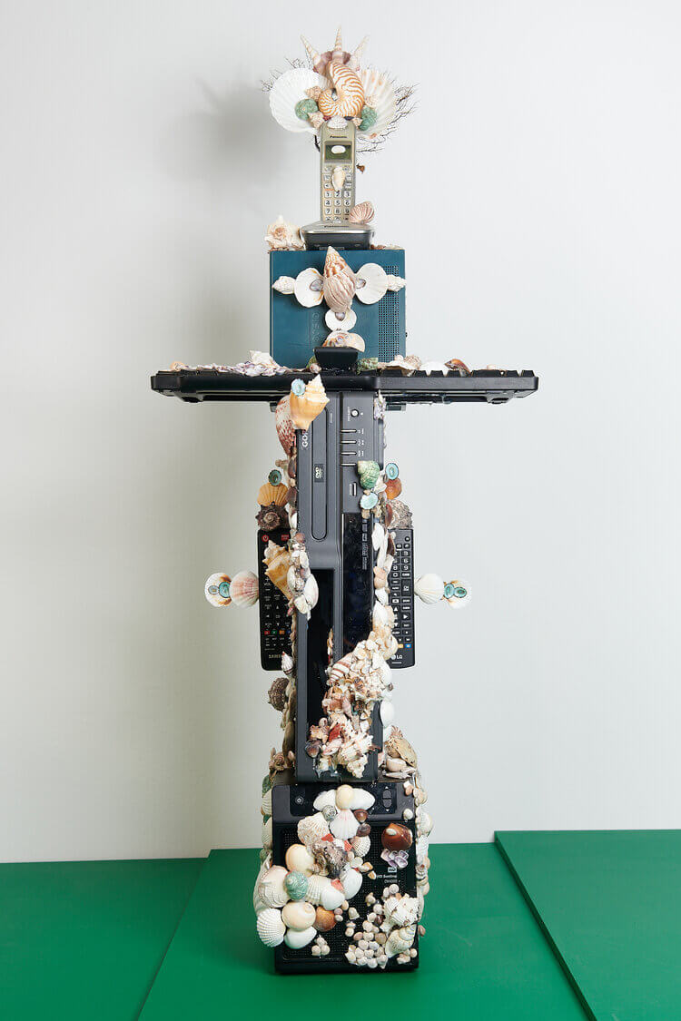 A crucifix arranged of electronic devices and covered in shells