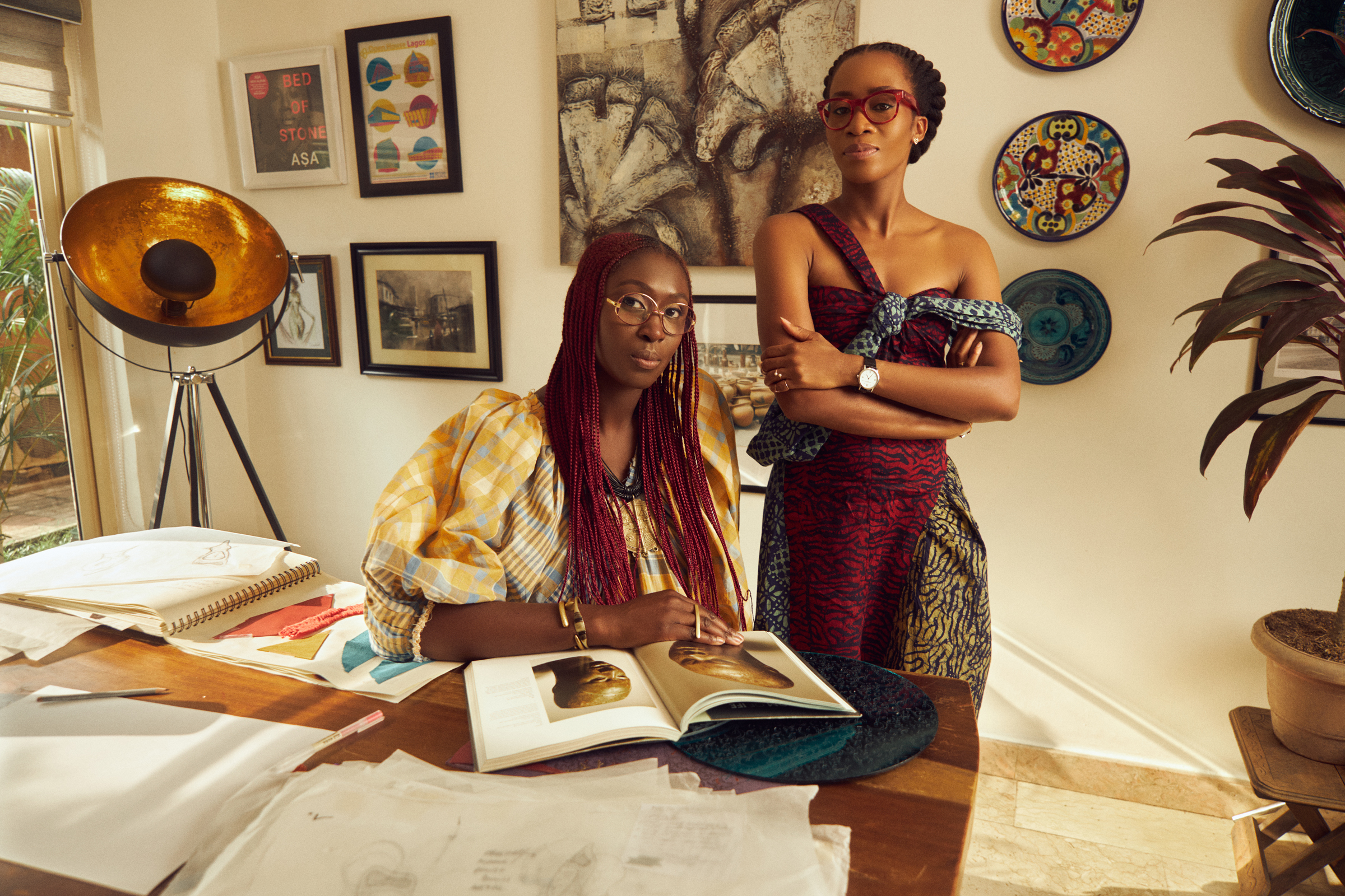 two women, the freedom to move designers, in a room with framed photos