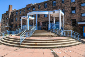 Exterior of the Willert Park Courts public housing complex with blue pergola in front of the entrance