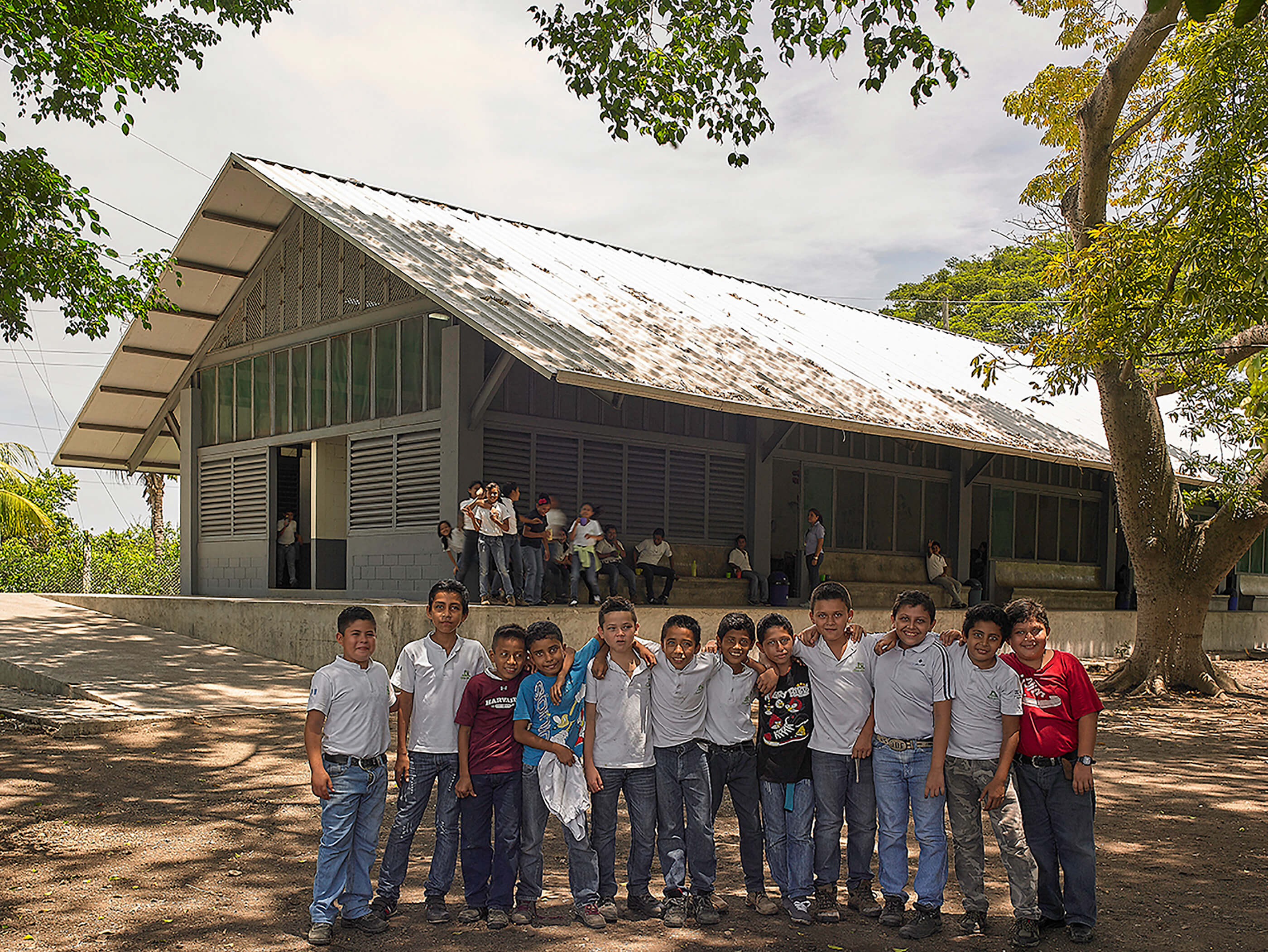 a long gabled house with children in front, designed by Cúre & Penabad