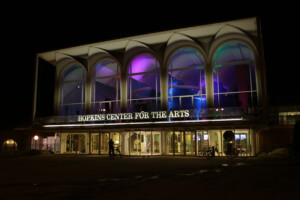a college arts center pictured at night with 