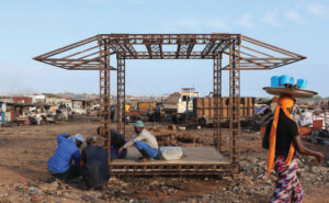 Construction workers setting up a pavilion in africa designed by low design office