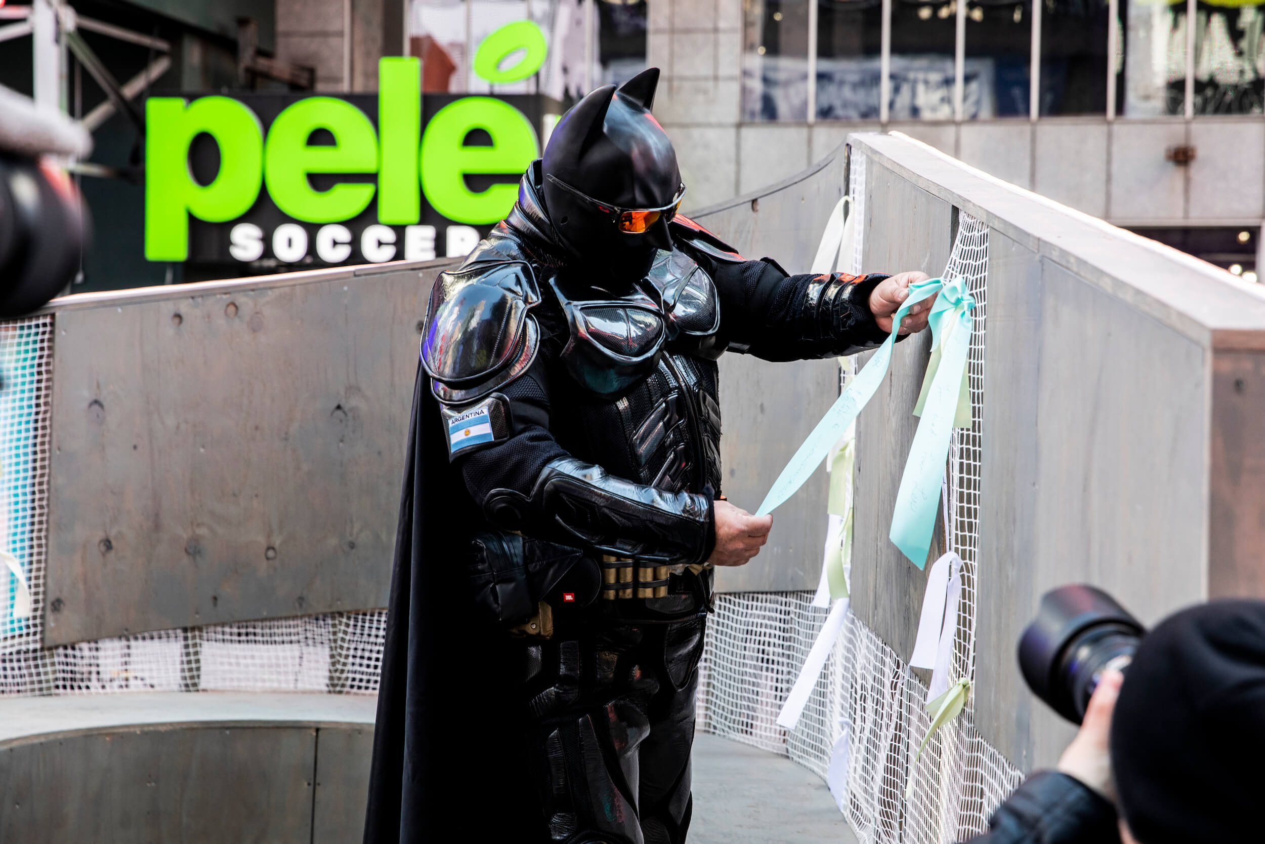 batman ties a ribbon to a public art installation