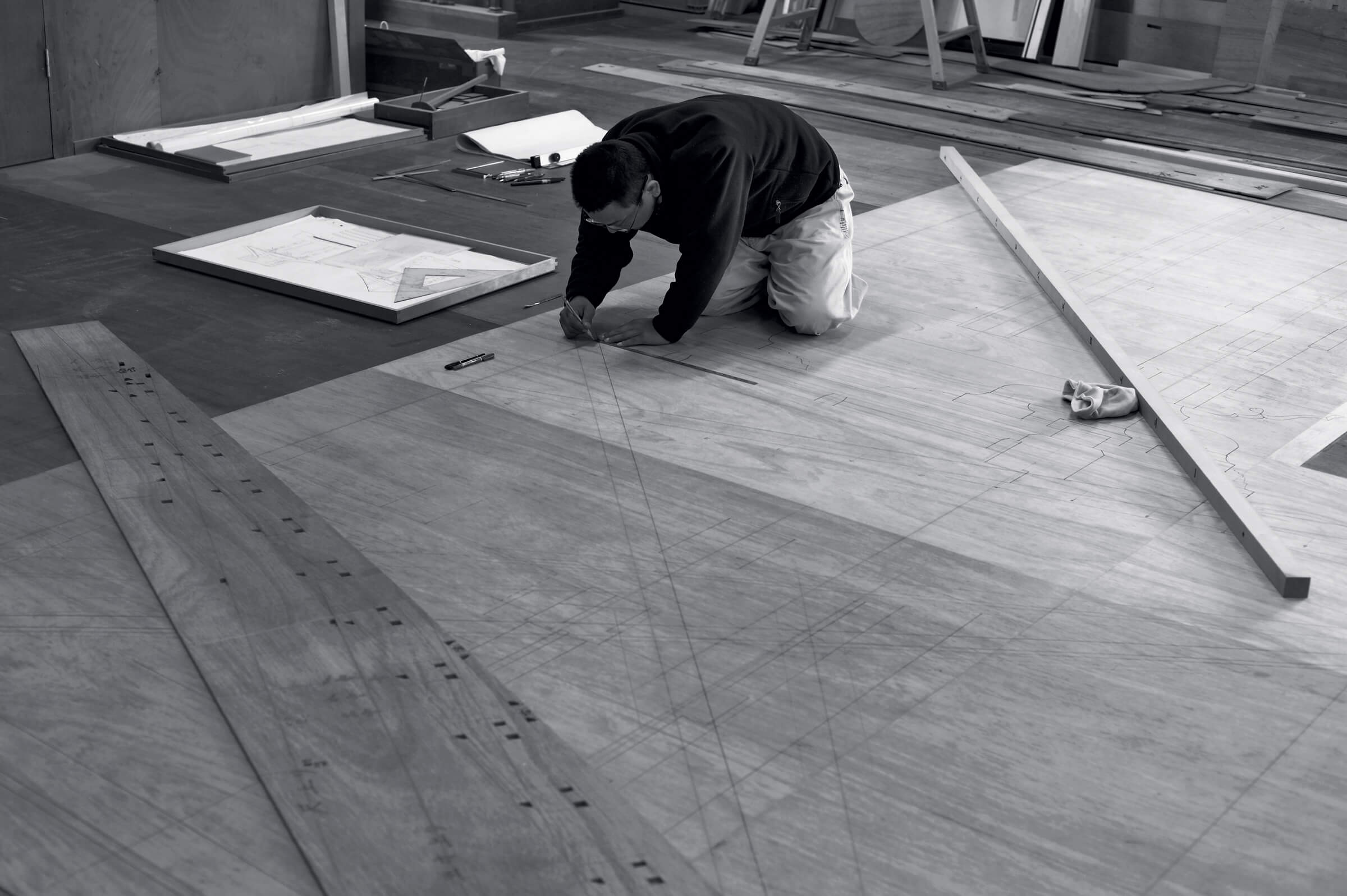 Photo of person drawing on the floor on very large sheets of paper