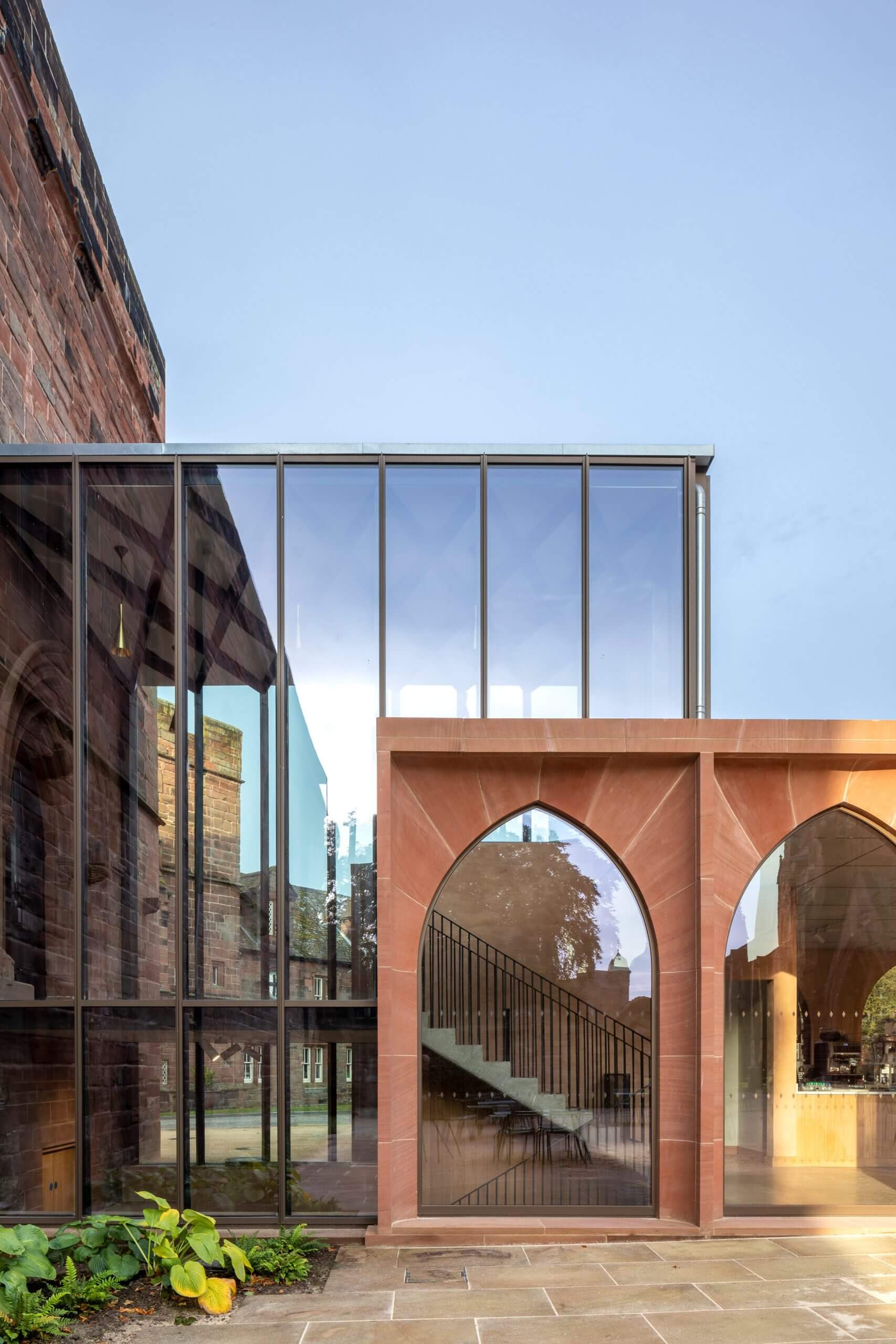 A stone arched facade meeting a cubic glass volume