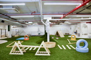 A green playscape in an industrial setting designed by overlay office