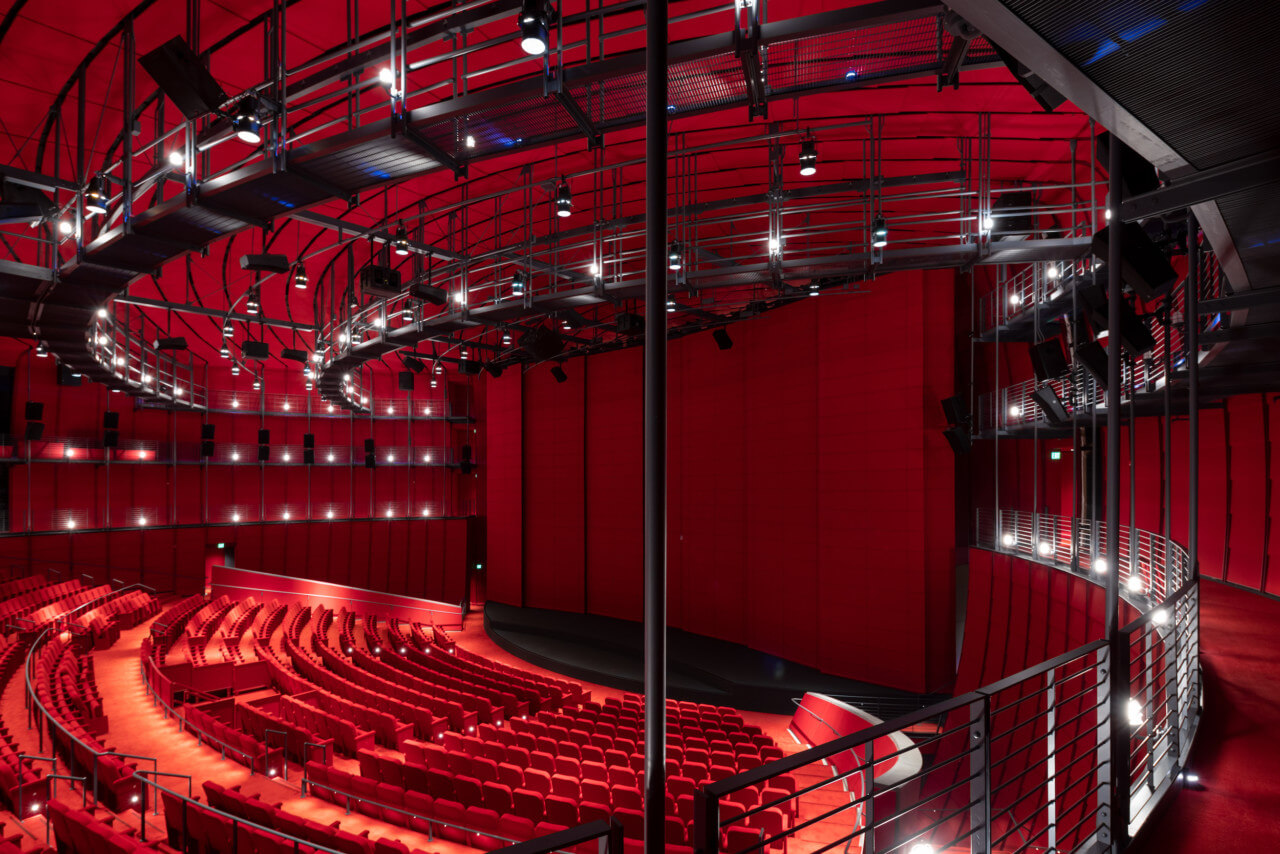 a theater space with red seats and walls