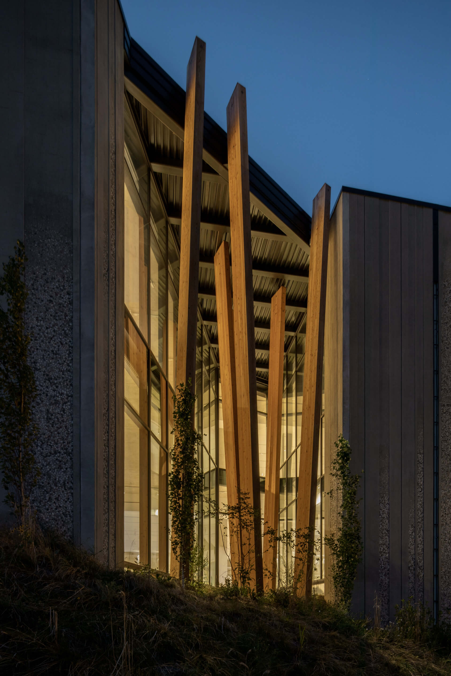 building exterior with soaring timber planks at night