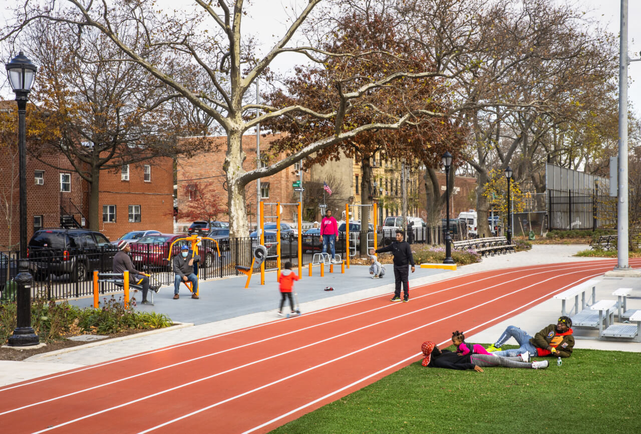 a running track flanked by outdoor exercise equipment