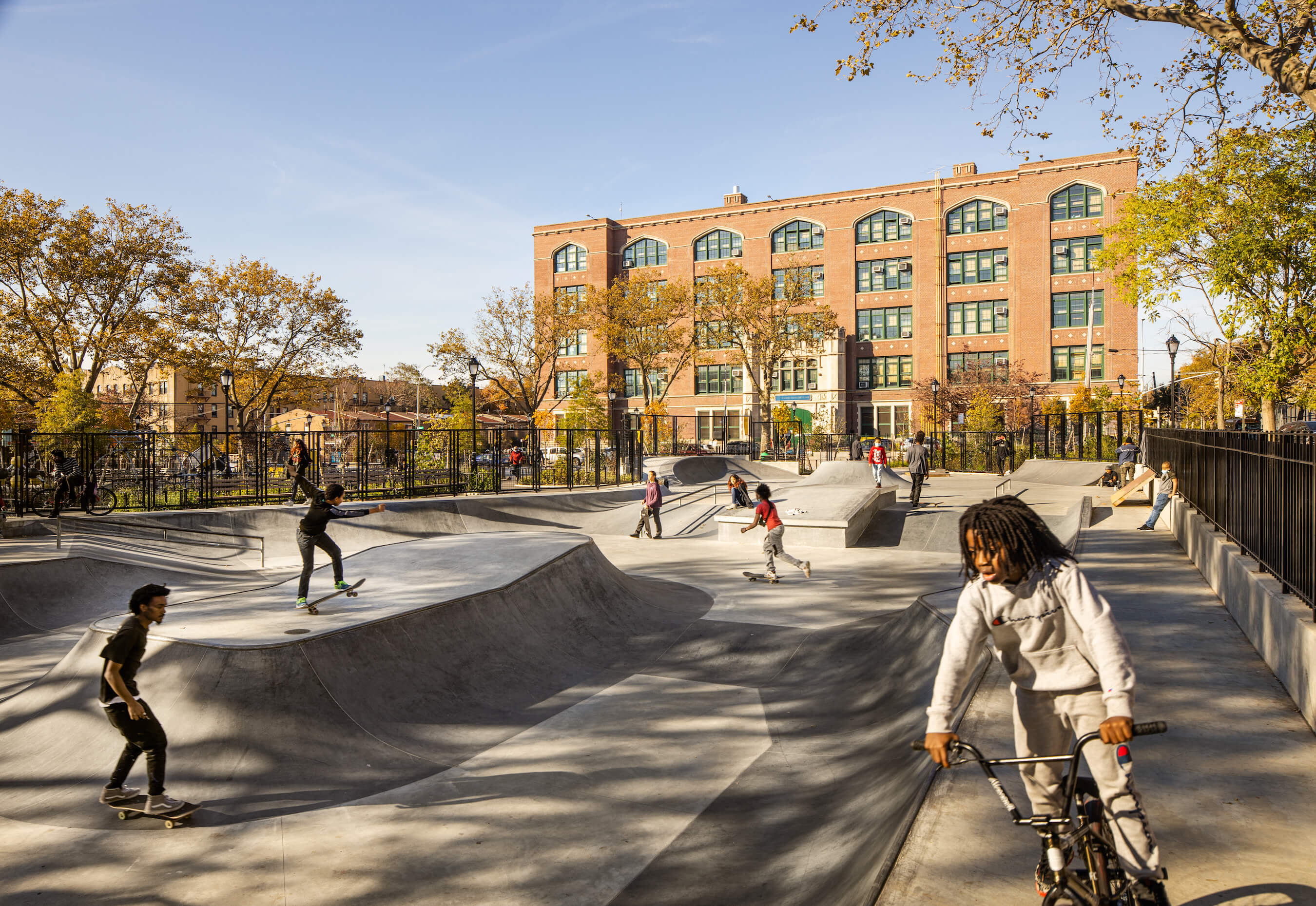 kids skateboard and bmx bike around an urban skate park at betsy head park