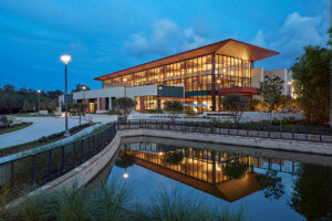 Exterior of the Center for Health & Wellbeing at night, on the water
