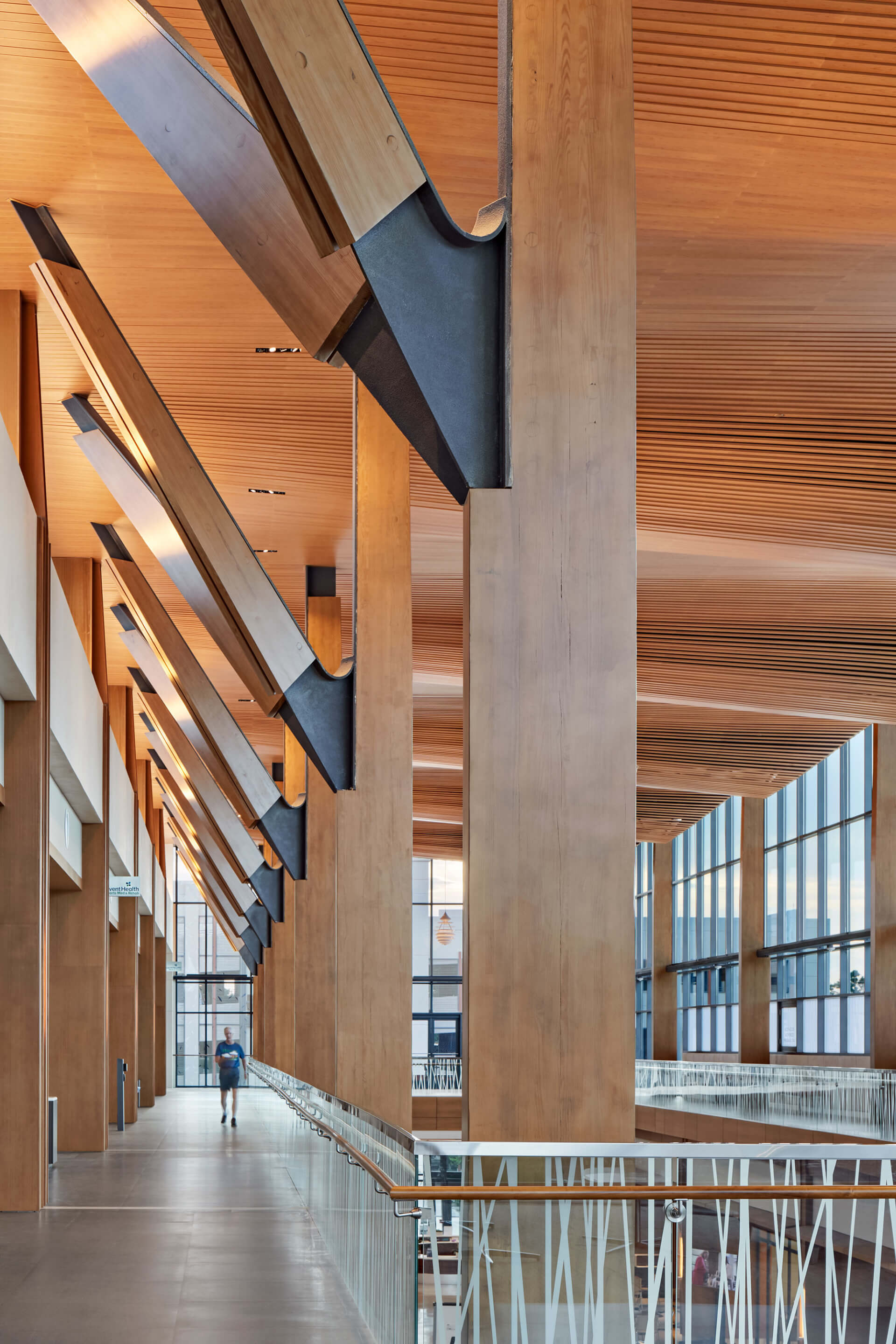Interior of a health center supported by massive timber columns running through an atrium