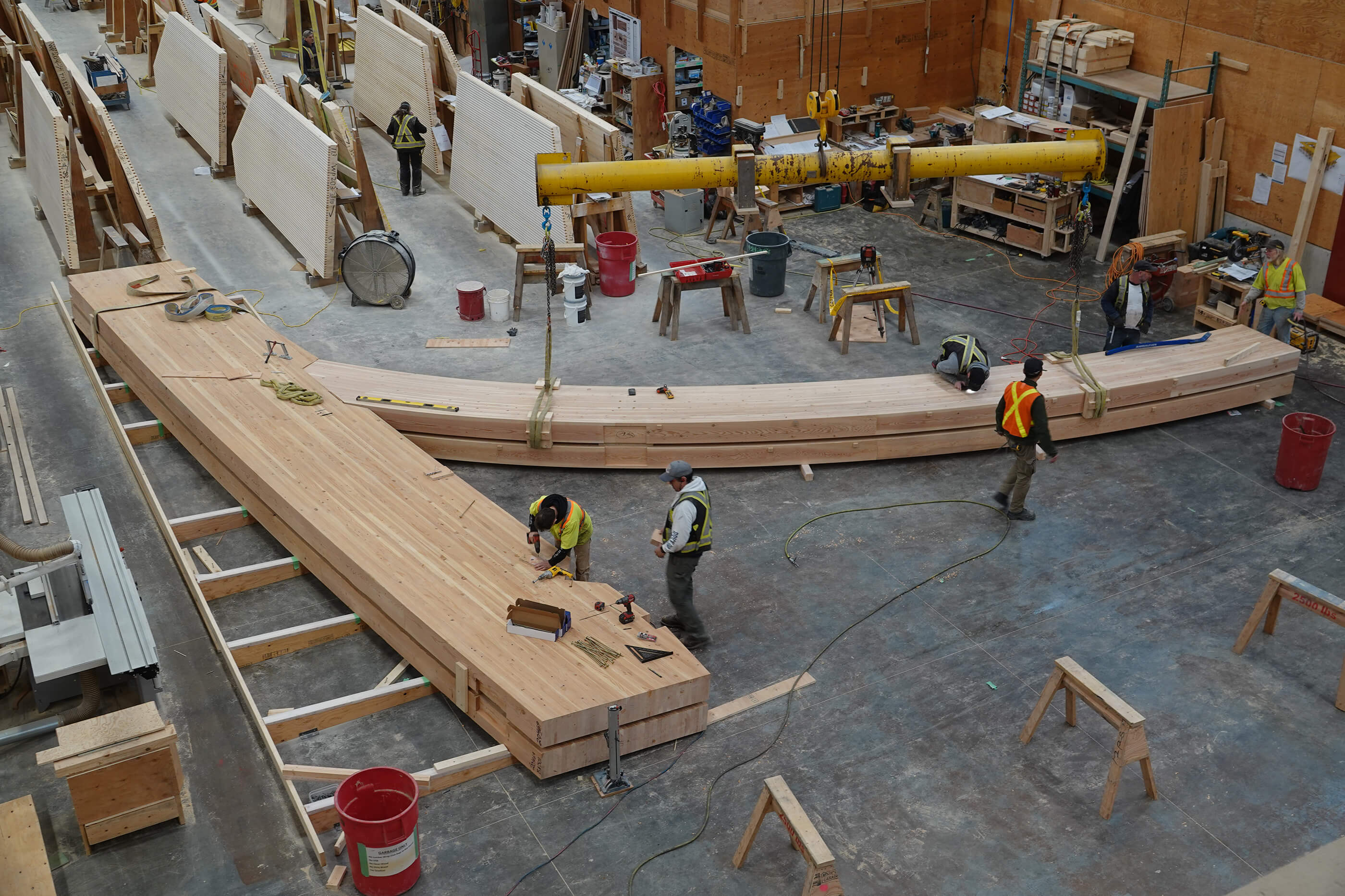 Aerial photo of construction workers assembling large timber trusses