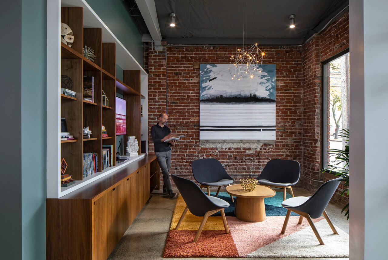 a cozy library/lounge room with a brick wall