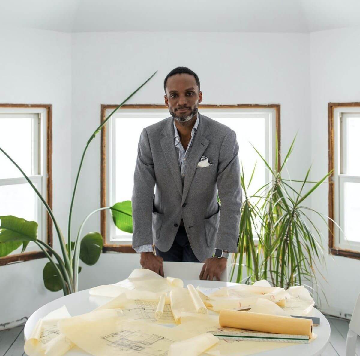Sekou Cooke in a gray suit in front a window