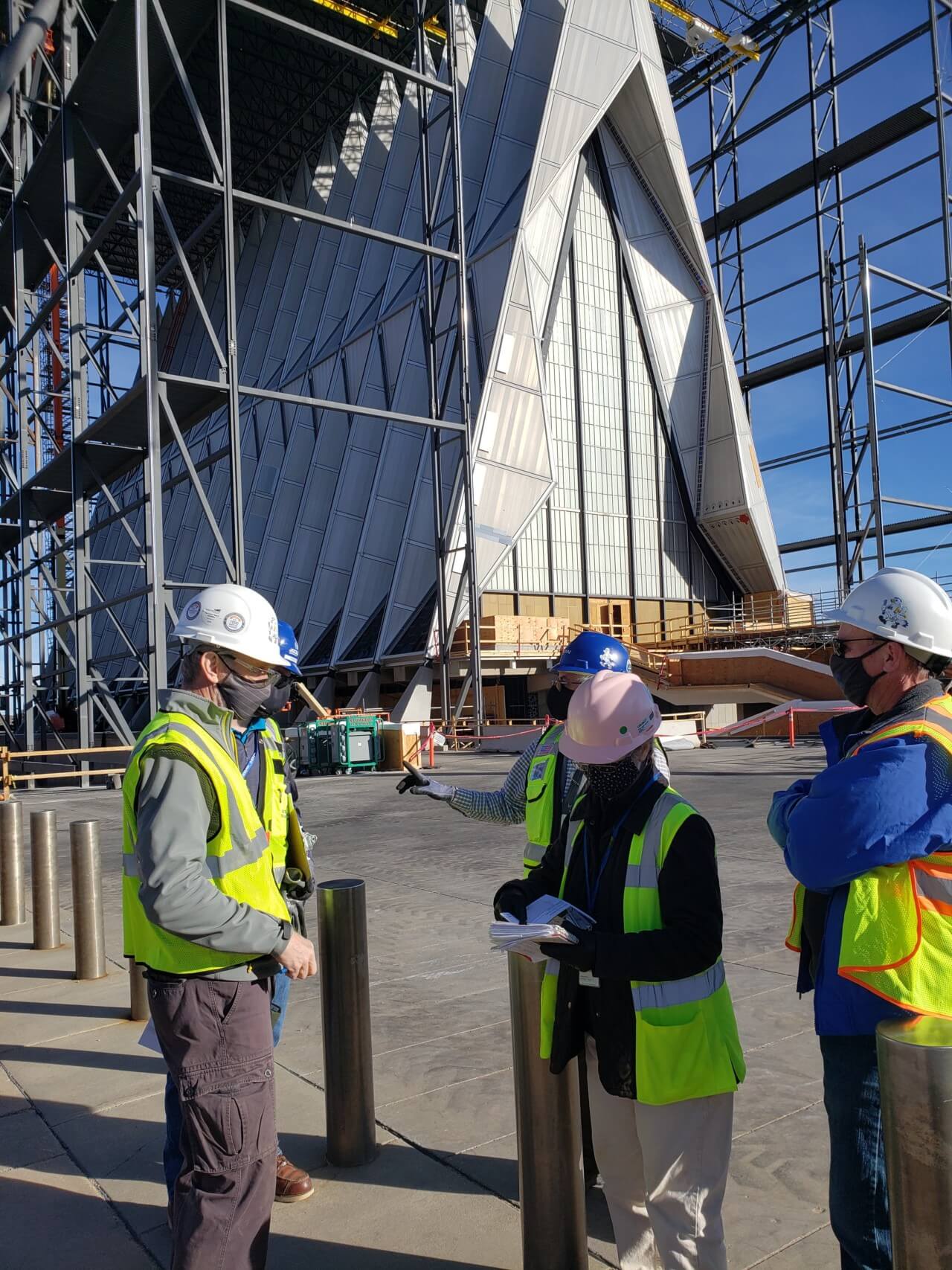 a team of construction workers in front of the air force cadet chapel