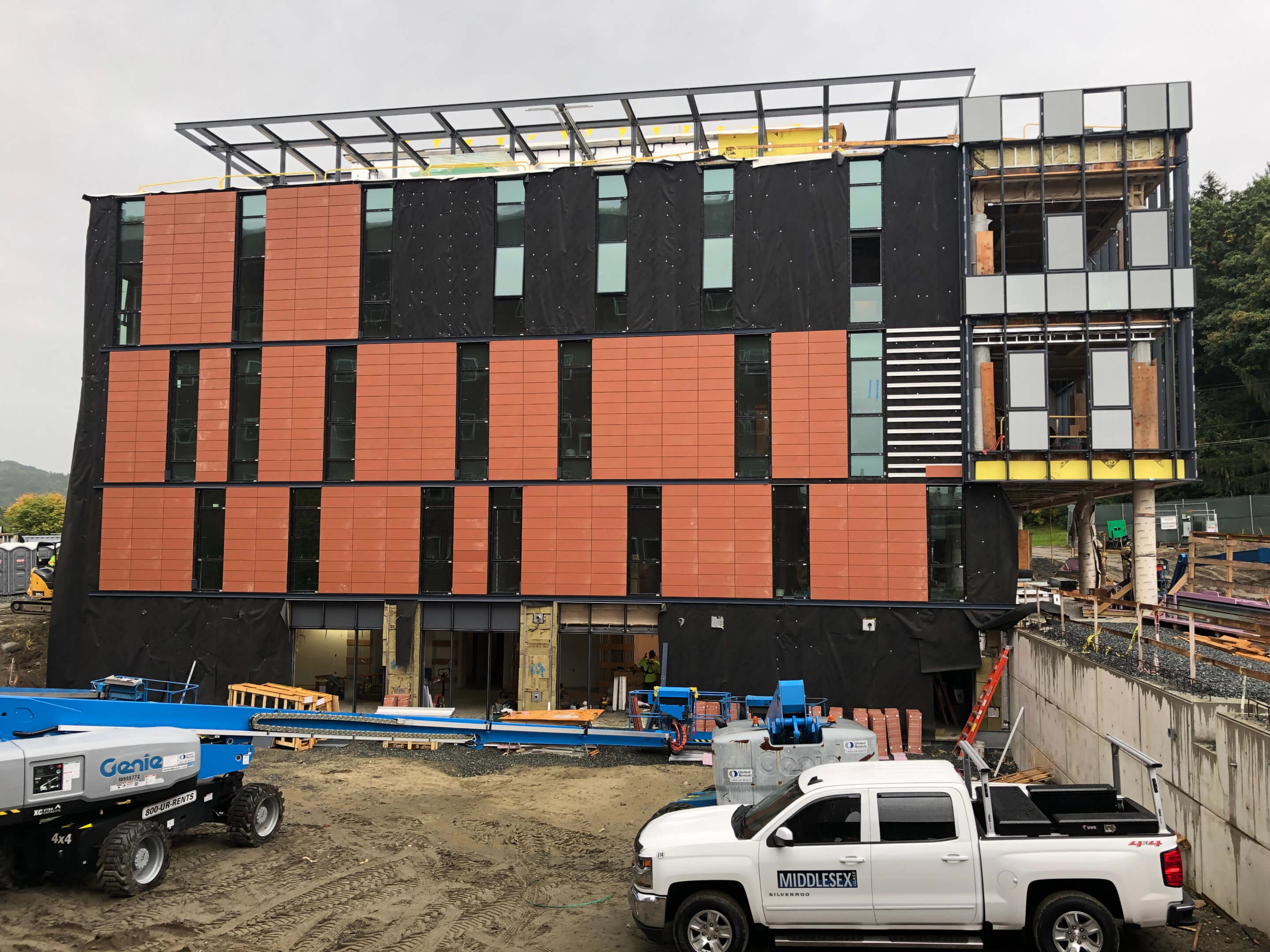 photo of construction of anonymous hall where terracotta thin tiles are being installed on the east facade 