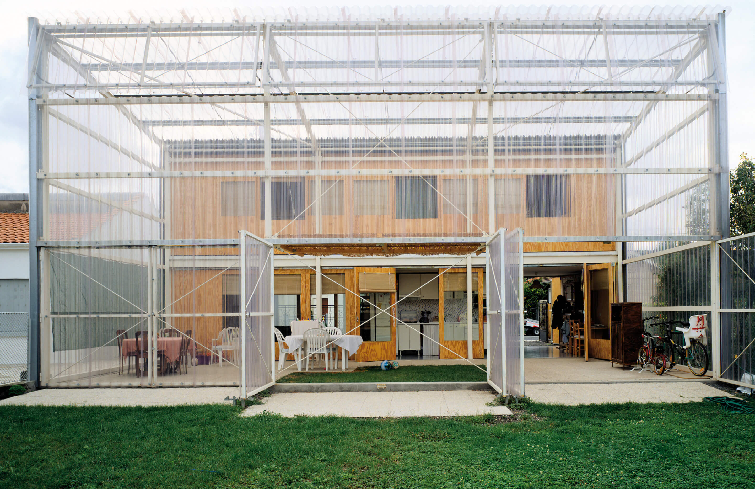 a single-family home with a large two-story greenhouse extension
