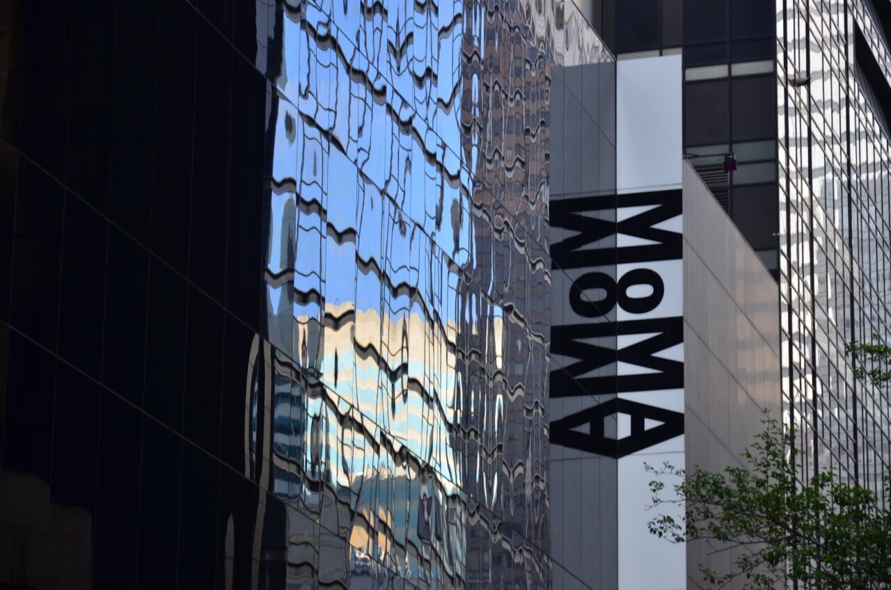 Sign and exterior of the Museum of Modern Art in New York, with the philip johnson gallery now covered (reading moma)