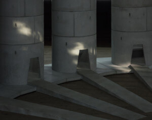 photo of concrete cylinders arranged for the pipes, with paths leading into each