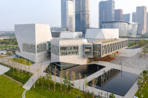 The Tianjin Juilliard School, crystalline structures rendered in concrete above a pond