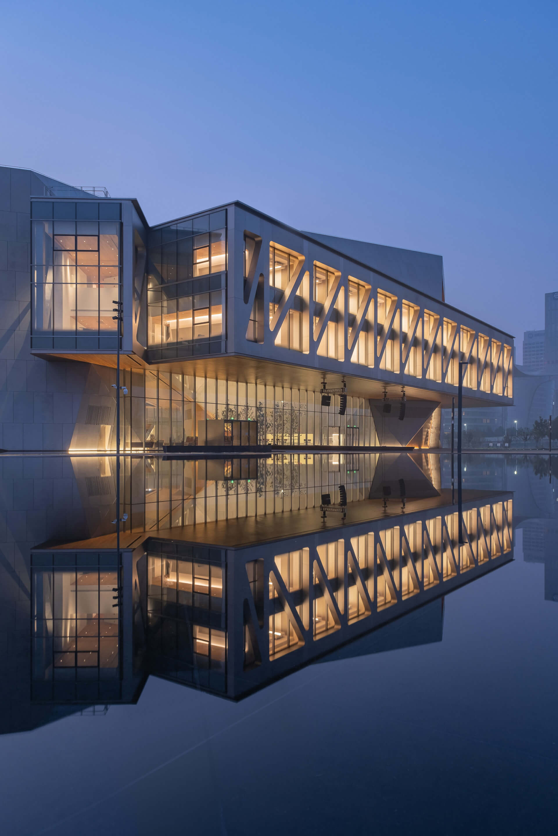 A cantilevered exoskeleton-clad structure over a reflecting pool