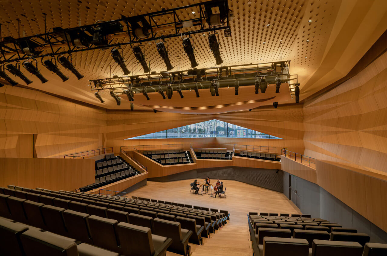 Rehearsal inside of a large wood paneled concert hall