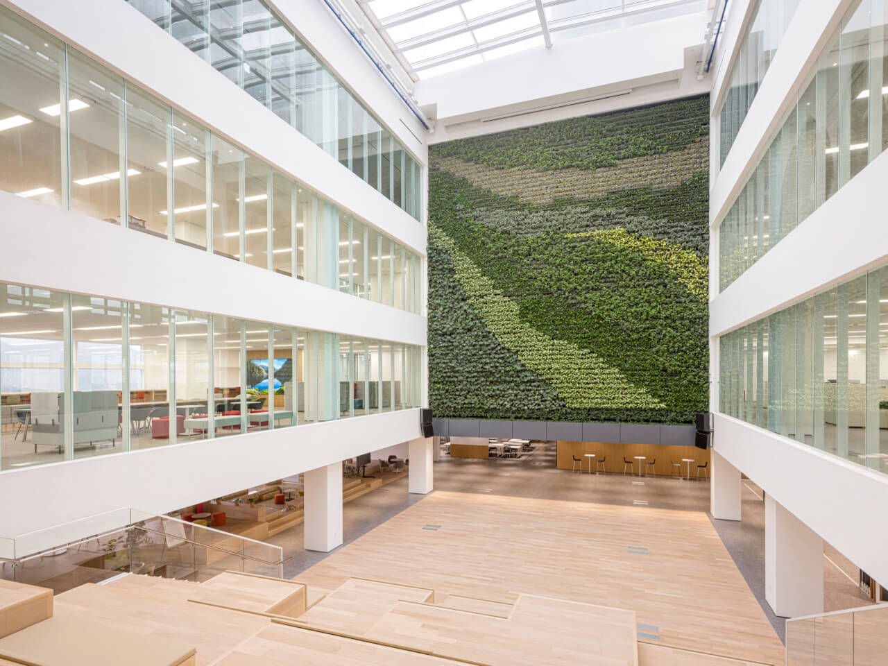 a large green wall in an open social space in an office building