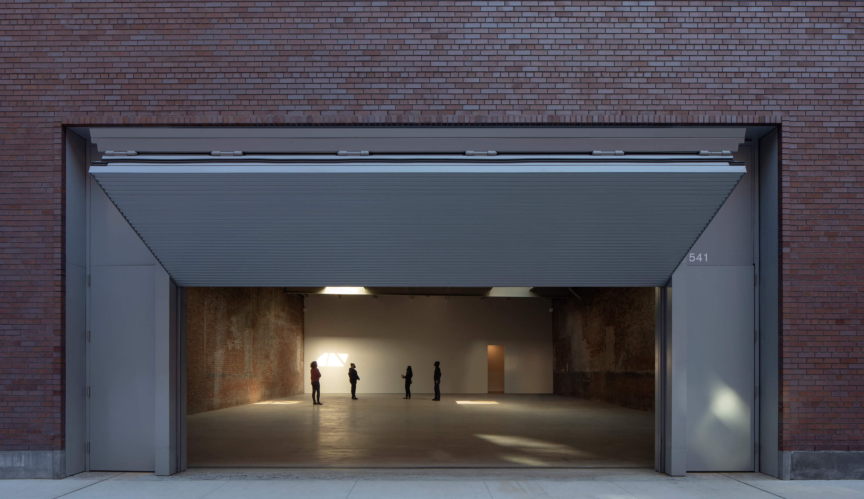 A sliding garage door leading into a gallery space