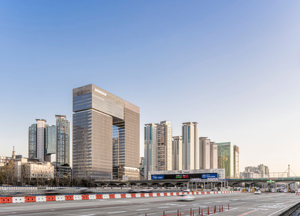 a stacked tower and other high-rises line a freeway in korea