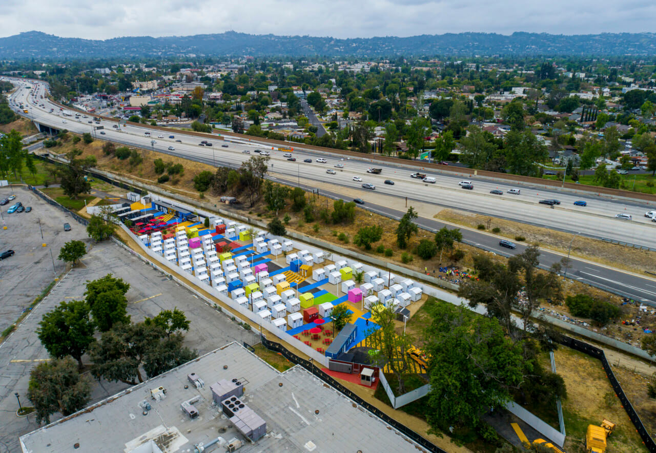 aerial view of a tiny house community adjacent to a freeway