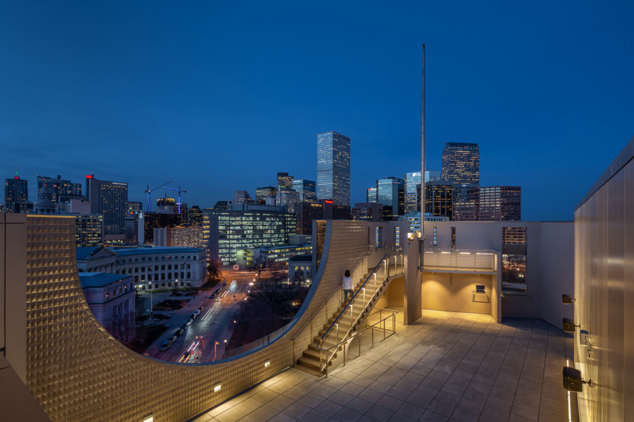 view of the denver skyline from a roof terrace at night