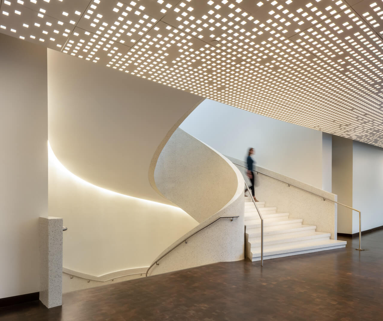 a person descends a staircase in a museum building