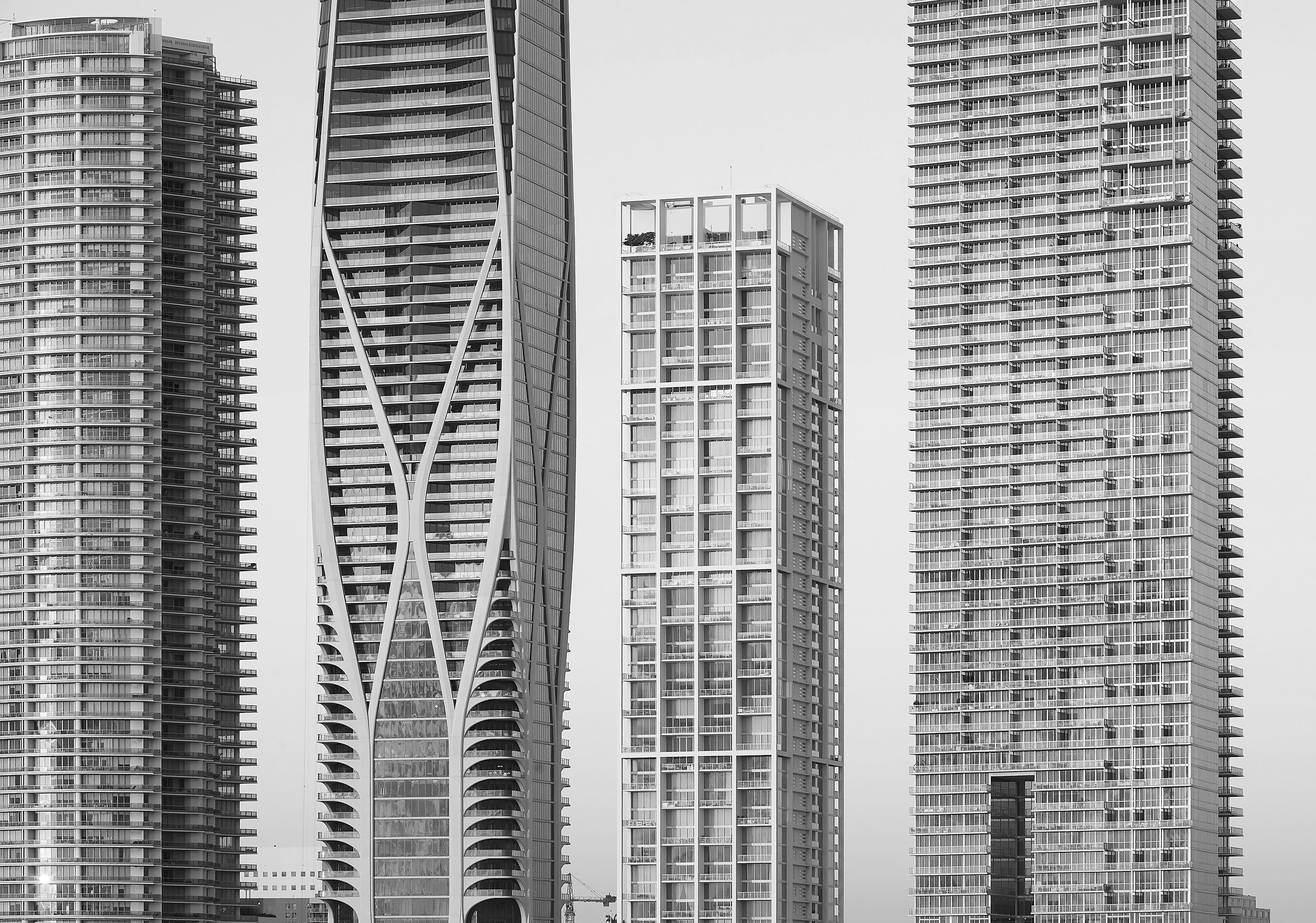 Black and white photo of thin Miami towers next to each other against the sky