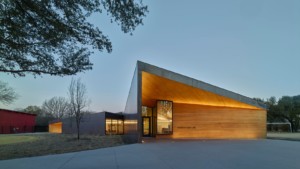 an illuminated science education building with an angled roofline, an AIA 2021 Architecture Awards winner