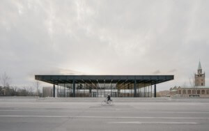 a cyclist passes a glass and steel museum building