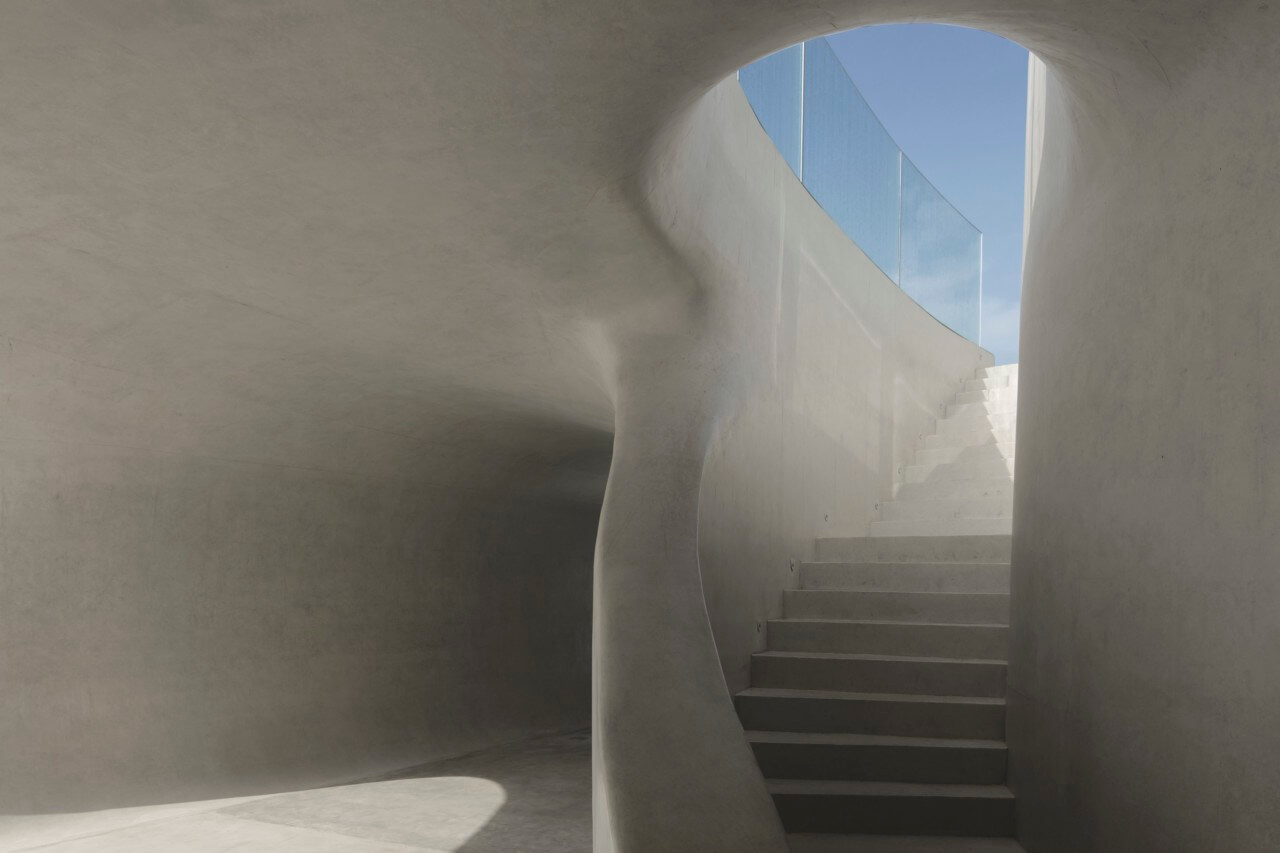 Looking up a sweeping white concrete staircase