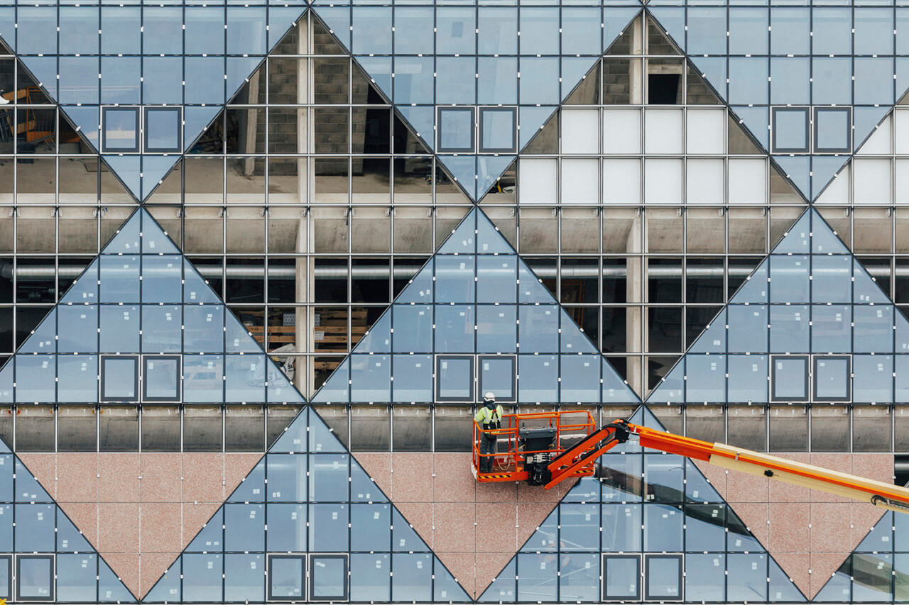 A worker installing triangular windows in london's design district
