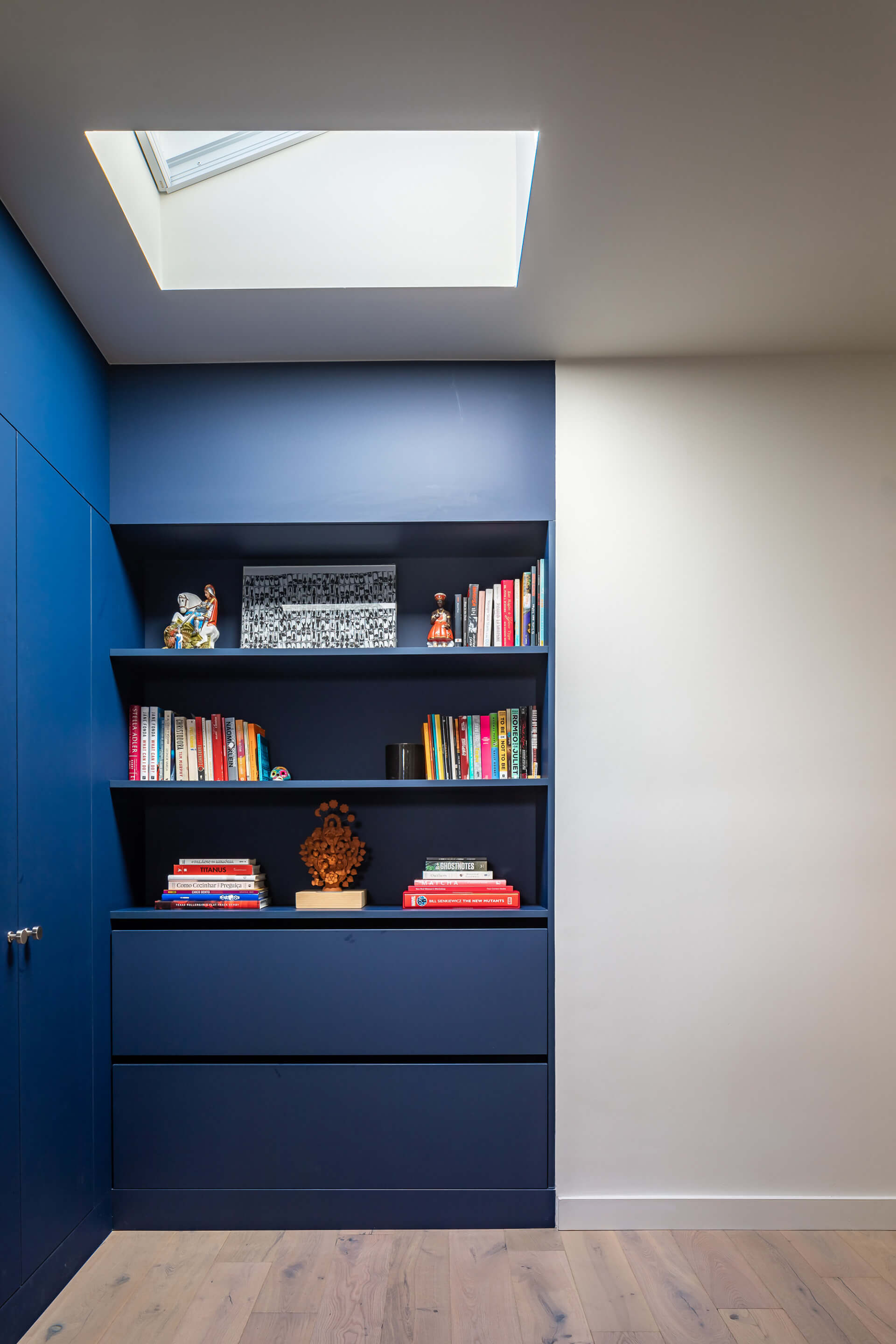 A skylight in a PRODUCTORA designed home with blue bookshelf