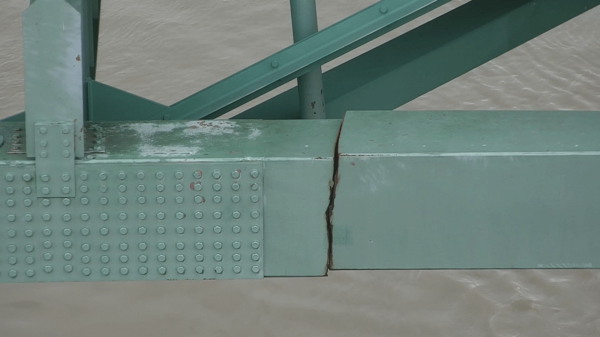 a large crack in a steel span of a bridge