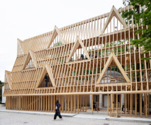 a four-story stick frame wooden house with person in front, which will help host the Transnational Midissage