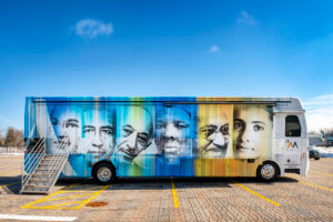 a bus, the Mobile Museum of Tolerance, with faces on it