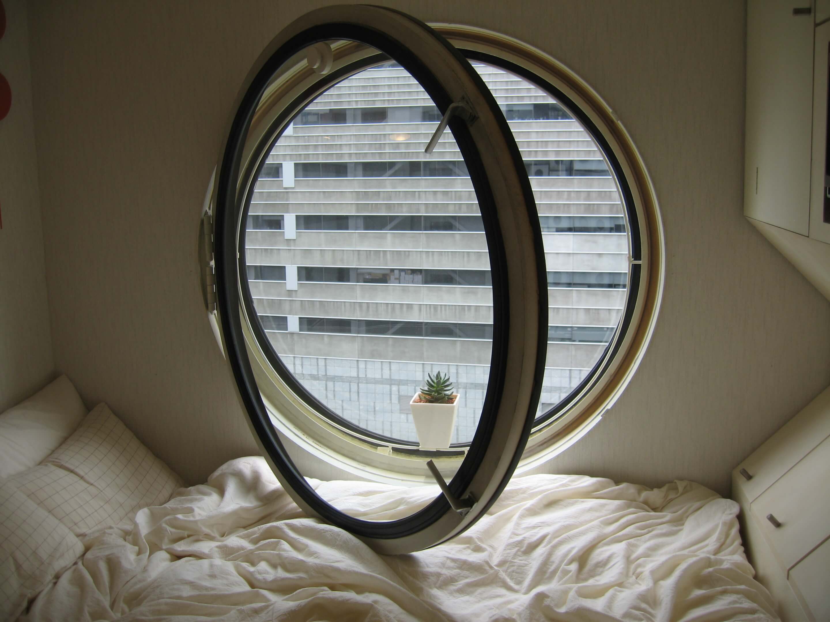 a large circular window inside a tiny apartment.