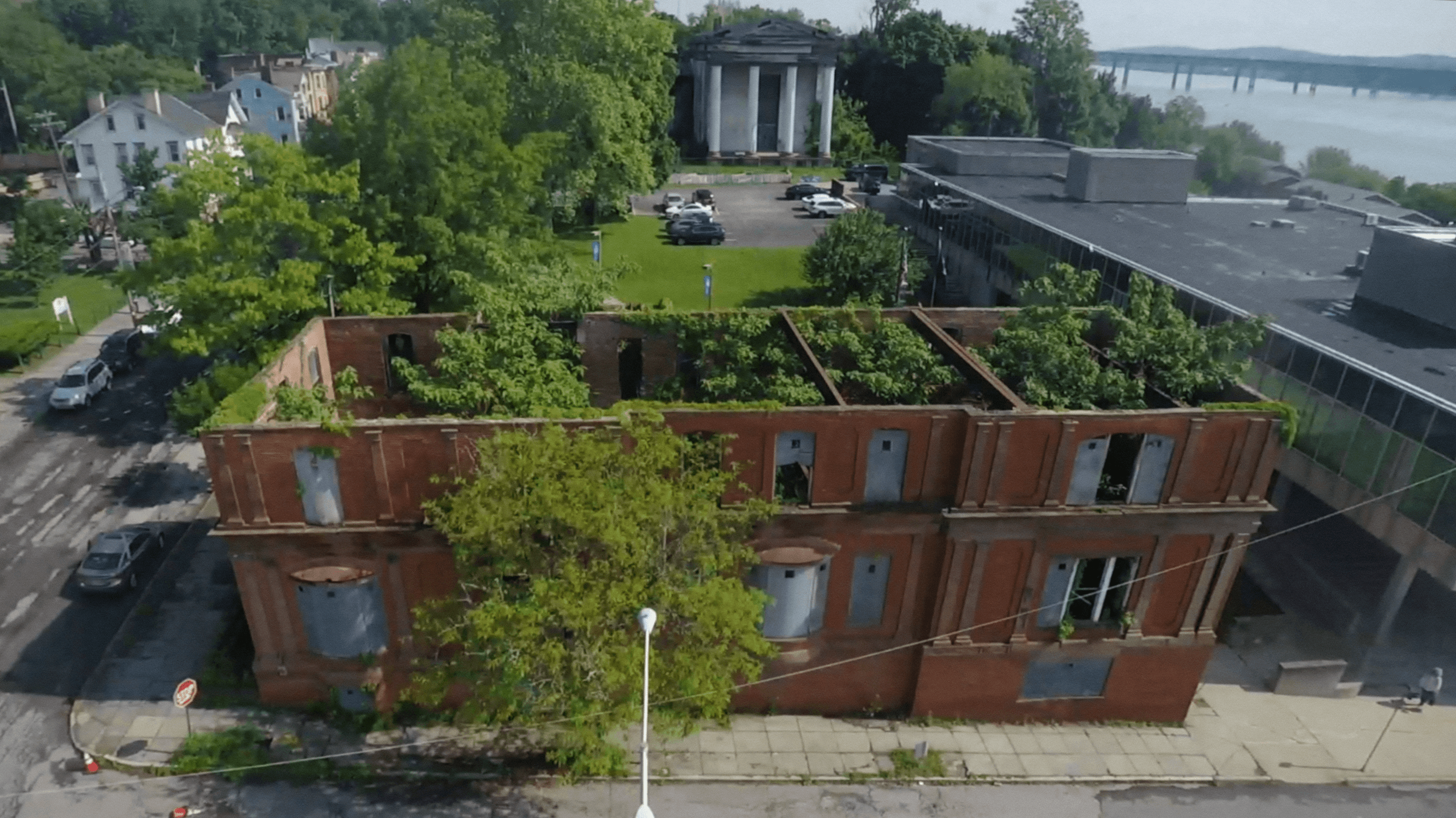aerial view of a gutted historic building with plants and trees growing inside