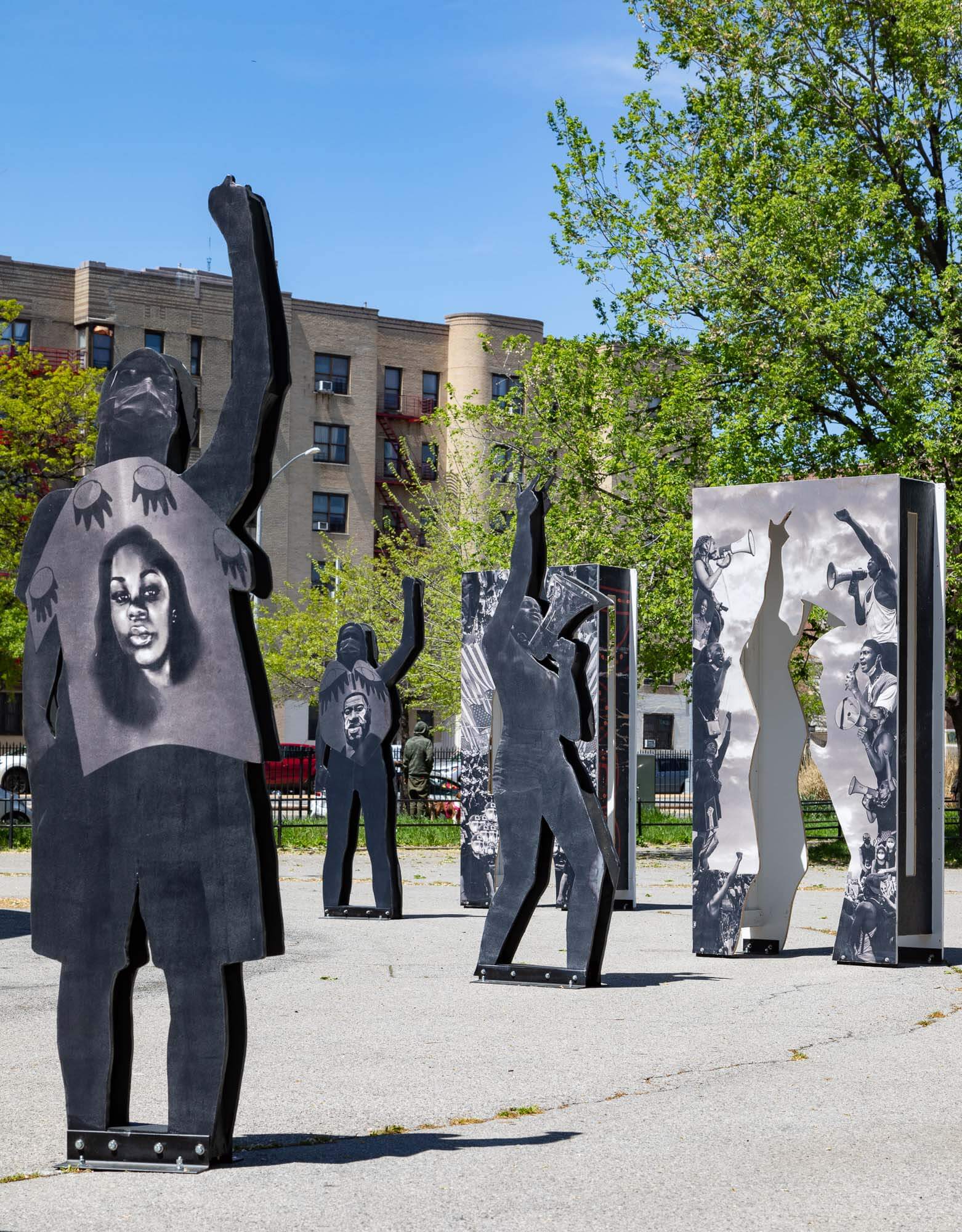 a collection of life-sized plywood cut-out figures representing protestors